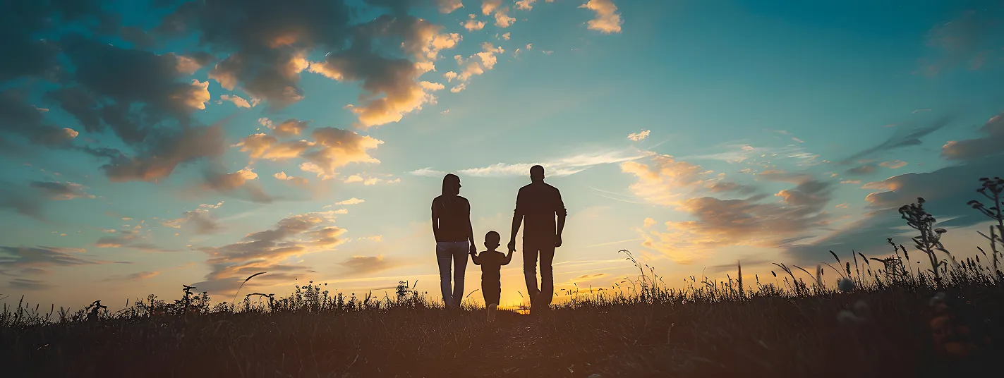 Família caminhando de mãos dadas ao pôr do sol